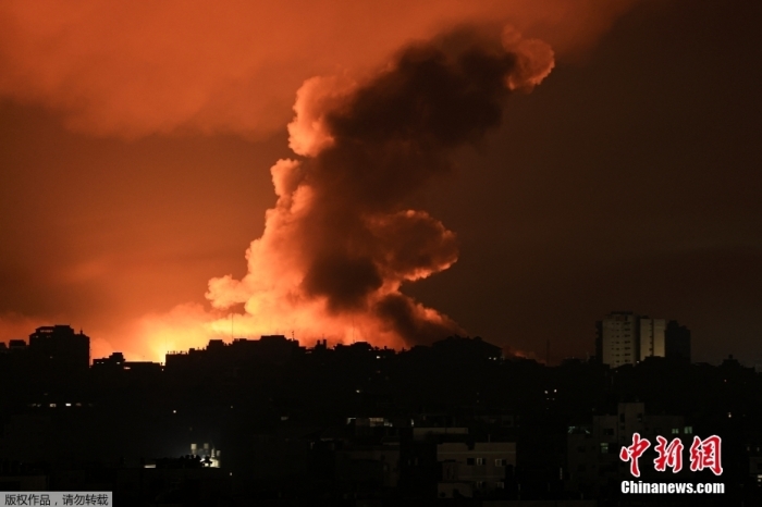 资料图：遭空袭后加沙城上空火光冲天，升起滚滚浓烟。
