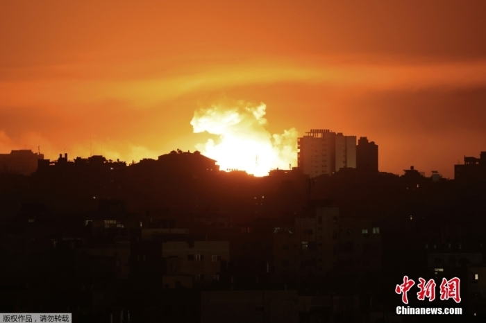 图为当地时间10月13日，遭空袭后加沙城上空火光冲天，升起滚滚浓烟。