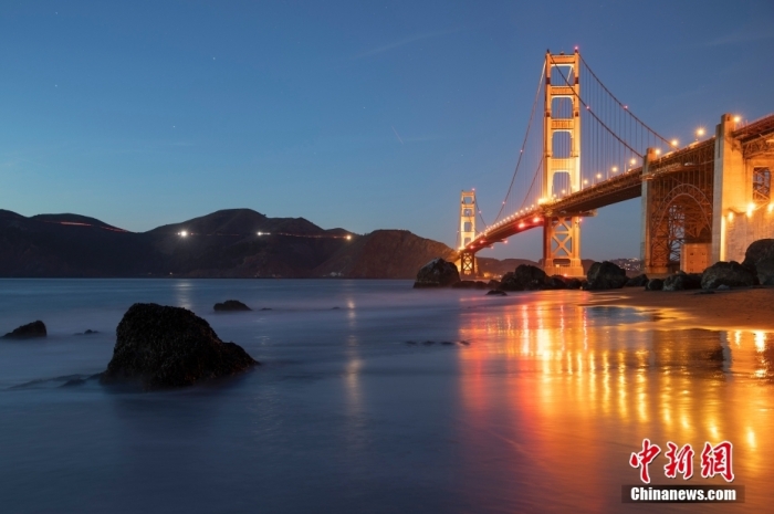 当地时间10月29日，美国旧金山金门大桥在海浪和夜色的衬托下美如一幅画。
中新社
记者 刘关关 摄