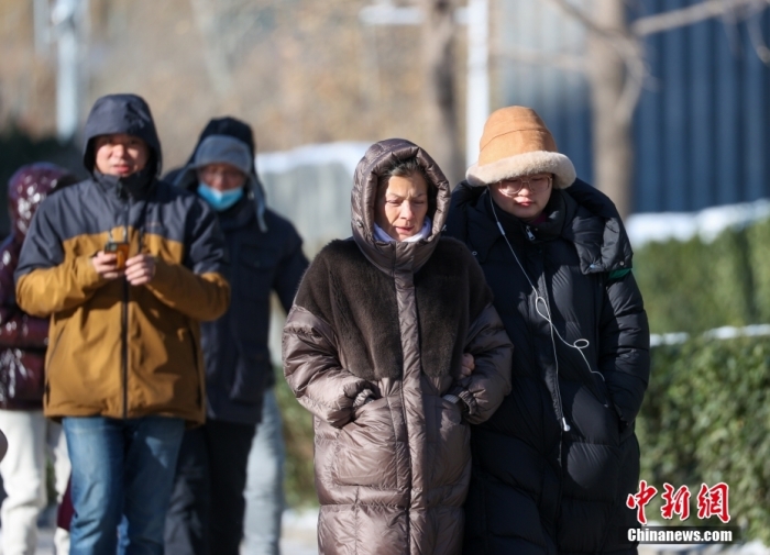 12月16日，受寒潮天气影响，北京气温大幅下降，最高气温仅有零下7℃。图为民众在寒冷天气中出行。
中新社
记者 贾天勇 摄