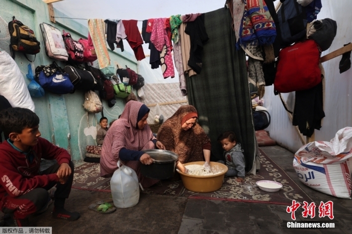 图为当地时间12月27日，流离失所的巴勒斯坦人在加沙地带南部拉法的一个帐篷内居住。