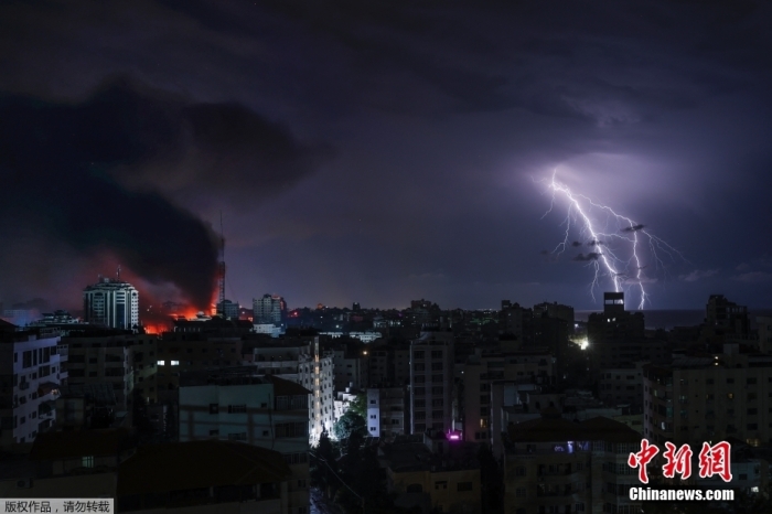 图为10月9日，加沙城，以色列轰炸后，紫色的闪电旁是滚滚浓烟。