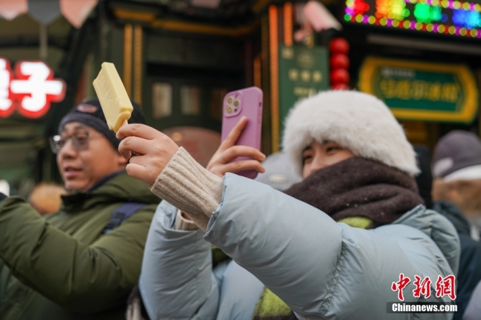 1月2日，在黑龙江哈尔滨中央大街，游客身着厚衣服在寒冷的天气中品尝雪糕，手拿雪糕拍照，成为哈尔滨冬日一景。图为游客拍摄雪糕。
中新社
发 赵宇航 摄