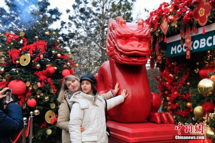 当地时间2月9日，中国农历新年庆祝活动启动仪式在莫斯科市中心的卡梅尔格尔斯基巷举行。中国驻俄大使张汉晖，俄罗斯外交部发言人扎哈罗娃，以及俄罗斯文化部和莫斯科市政府官员出席。庆祝活动将持续至18日。图为当地民众在特维尔广场与龙雕塑合影。