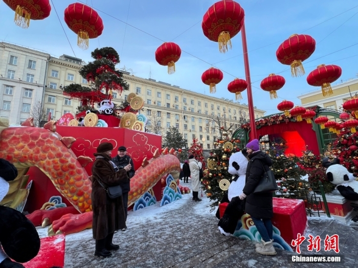 当地时间2月9日，中国农历新年庆祝活动启动仪式在莫斯科市中心的卡梅尔格尔斯基巷举行。中国驻俄大使张汉晖，俄罗斯外交部发言人扎哈罗娃，以及俄罗斯文化部和莫斯科市政府官员出席。庆祝活动将持续至18日。图为当地民众在特维尔广场与大熊猫玩偶合影。中新社记者 田冰 摄