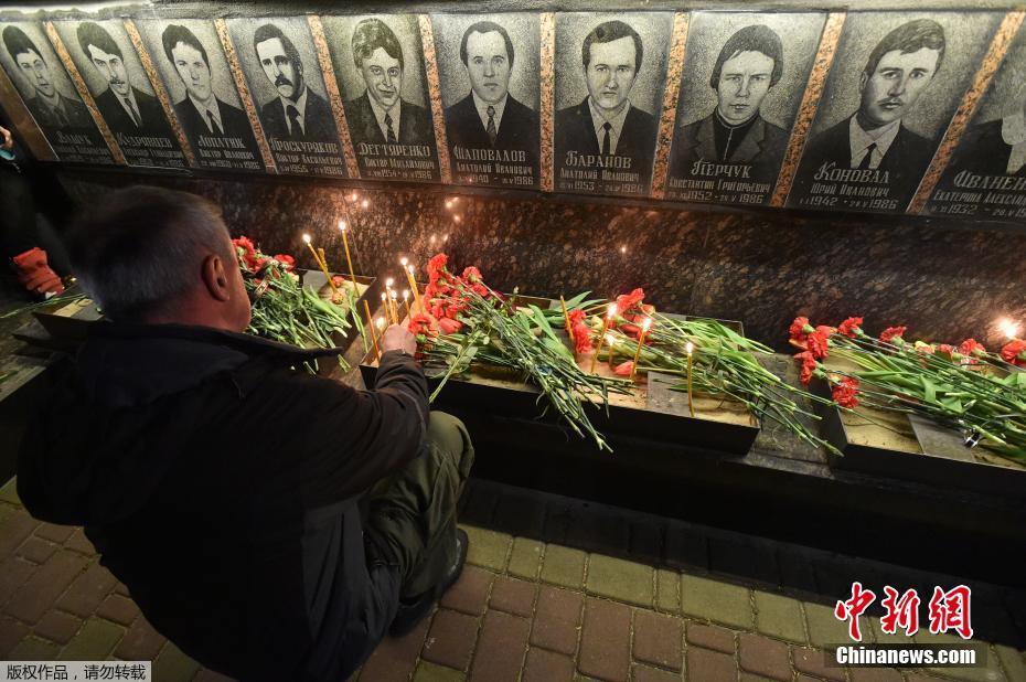 图为乌克兰slavutich民众凌晨前往墓地，点烛献上鲜花悼念在清理切尔诺贝利核事故中死亡的“清理人”（liquidators）。