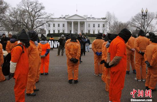 资料图：关塔那摩监狱建立9周年纪念日当天，美国华盛顿，示威者穿着橙色的囚服游行，要求关闭关塔那摩监狱。。