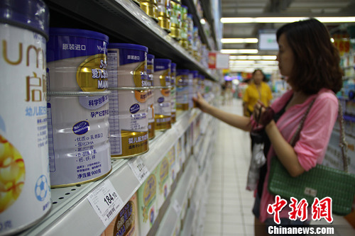 湖南长沙某超市内一名市民挑选进口奶粉(资料图)。发 杨华峰 摄