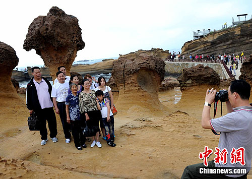 “十一”长假期间，台湾野柳地质公园内蜂窝岩、豆腐岩、蕈状岩、姜状岩，风化窗等奇特岩层景观吸引众多大陆游客。中新社发 刘可耕 摄