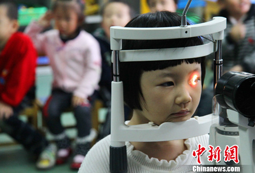 资料图：眼科医护人员正在检测孩子们的视力。中新社发 韩苏原 摄