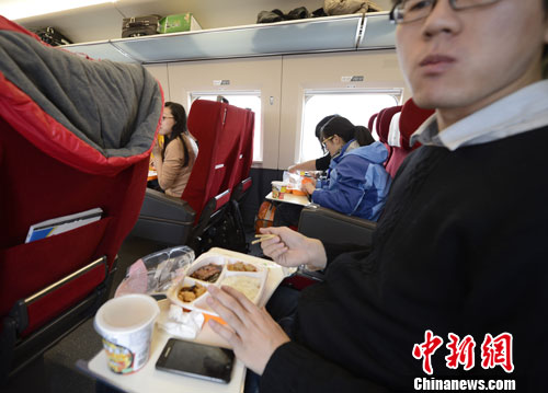 图为G801次列车一等座席的乘客在品尝列车提供的餐食。中新社发 侯宇 摄