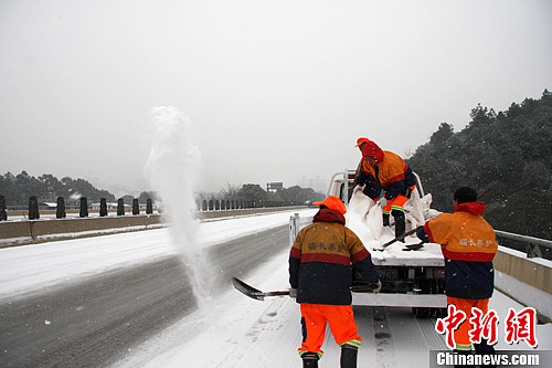 图为高速公路养护人员对路面撒盐。中新社发 刘剑 摄
