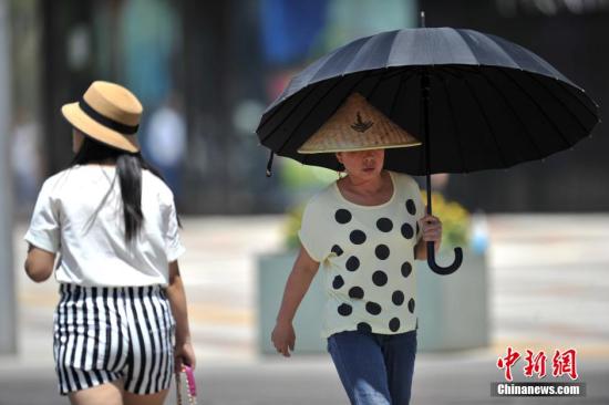 资料图：民众撑伞遮阳。中新网记者 金硕 摄