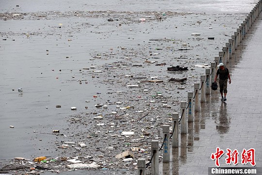 7月4日，山西太原遭遇暴雨袭击，雨水将大量垃圾冲入汾河公园河道内，致使河面漂浮大面积垃圾，造成河水污染。中新社发 武俊杰 摄