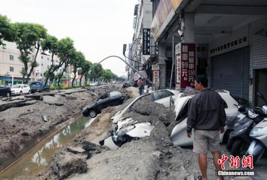 2014年8月1日，台湾高雄市前镇区气爆废墟，场景惨烈，显见气爆威力巨大。图为路树、路灯和小轿车“三叠”倒地。当天临近子夜时分，当地发生重大的可燃气体外泄爆炸事故，破坏力惊人，造成人员大量人员伤亡。黄少华 摄