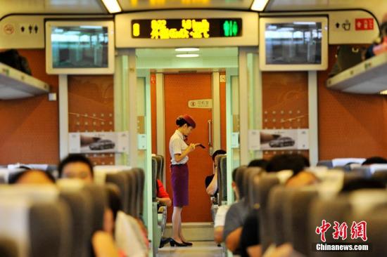 资料图：2014年8月8日，兰渝铁路高南线开通运营。图为D5176次动车乘务员为旅客服务瞬间。 安源 摄