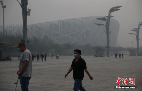 资料图：游客戴口罩在北京奥林匹克公园游玩。中新社发 刘关关 摄