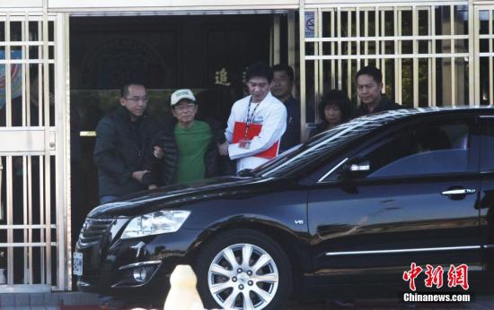 资料图：2015年1月5日，台湾当局前领导人陈水扁获准保外就医。图为陈水扁儿子陈致中将其推至台中监狱大门口，并搀扶他上车。 中新社发 路梅 摄