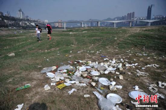 3月25日，长江重庆段裸露河床堆放着不少白色塑料垃圾。长江水位下降，大片河床裸露在外，成了市民休闲娱乐地。不少市民在此进行野外烧烤，留下了不少垃圾在河床上。陈超 摄