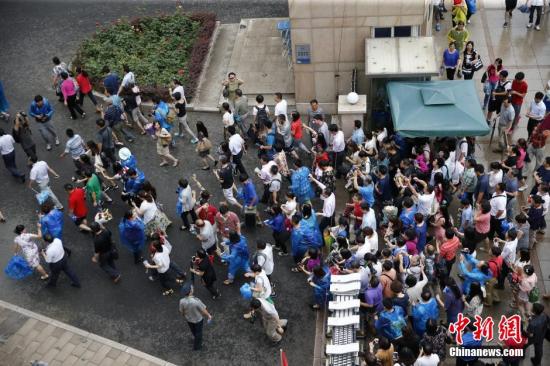 资料图：2015年6月8日下午，北京人大附中考点，众多家长在北京高考最后一门考试结束后冲进学校内迎接考生。中新社发 张浩 摄