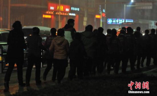2015年11月09日，辽宁省沈阳市，夜间雾霾严重持续未散，百人“暴走团”戴口罩现身街头。 图片来源：视觉中国