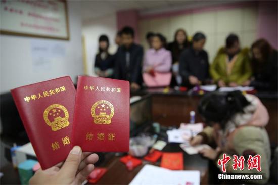 资料图：新人在婚姻登记处展示刚领取的结婚证书。 兰自涛 摄