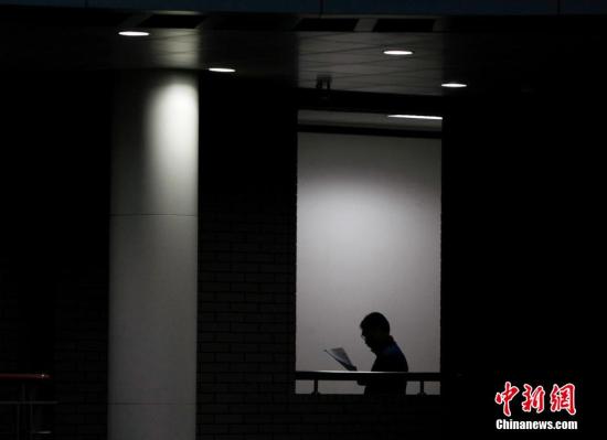 资料图：北京大学图书馆，一位读者站在过道里读书。 

中新社记者 刘关关 摄