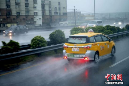 6月14日，车辆在通往桃园机场的路上疾驰，溅起水花。连日来，台湾多地遭遇豪雨。台农业部门14日表示，6月豪雨已累计造成全台农业产物及民间设施损失估计达1188万元新台币。中新社记者 陈小愿 摄