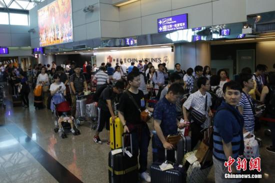 资料图：台湾桃园机场内，中华航空公司服务台前咨询航班信息或改签航班的旅客排起百余米的长队。 中新社记者 陈小愿 摄