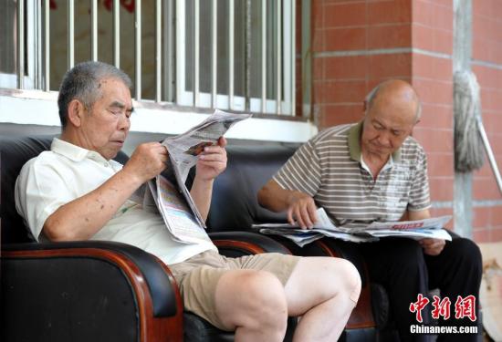 资料图：武汉洪山区通惠社区养老院安置点，2位老人悠闲地看着报纸。 记者 张畅 摄