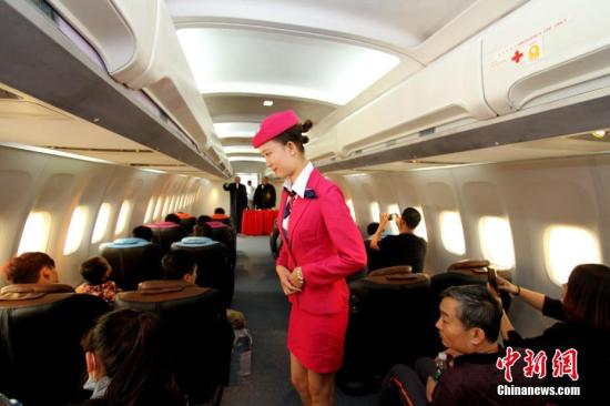 资料图：机舱“空姐”为乘客服务。中新社记者 张道正 摄
