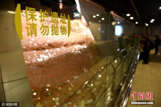 2016年11月20日，在浙江杭州雷峰塔雷峰塔地宫遗址，不少前来参观的游客都往遗址内扔钱。 图片来源：视觉中国