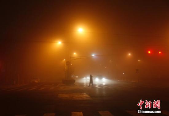 资料图：2016年12月31日，北京民众在雾霾中前行。 中新社记者 刘关关 摄