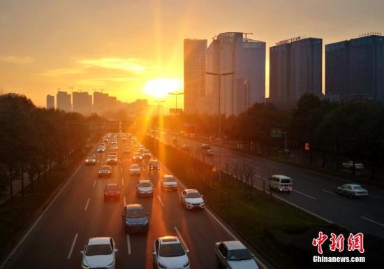 资料图：2月8日清晨，成都三环路穿行在金色阳光中的汽车。中新社记者 刘忠俊 摄
