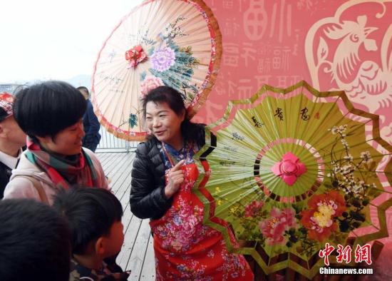 资料图：来自台湾高雄市油纸伞制作艺人向市民展示她的油纸伞作品。 刘可耕 摄