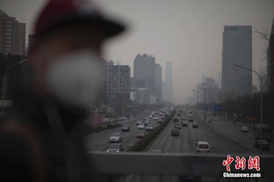 资料图：北京市民在雾霾中出行。中新社记者 刘关关 摄