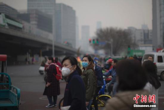 资料图：北京市民戴口罩出行。中新社记者 刘关关 摄