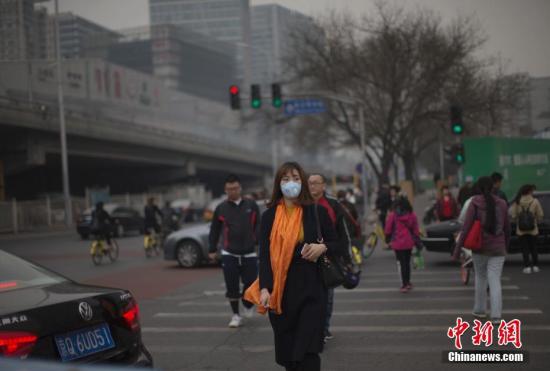 资料图：3月20日，北京市民在雾霾中出行。当日，京津冀环境气象预报预警中心发布的北京地区空气污染气象条件预报显示，北京当天白天大部分地区空气污染气象条件等级为3-4级。 中新社记者 刘关关 摄