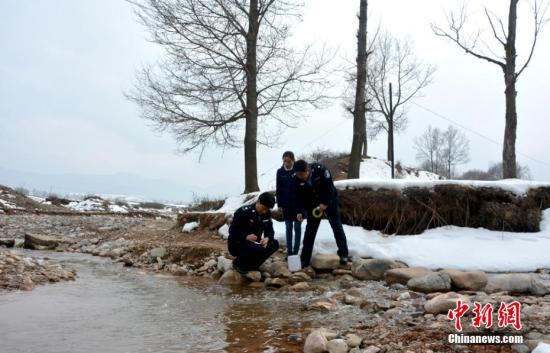 资料图：甘肃渭源县环保局执法人员在峡口水库水源地取样。 王纲 摄