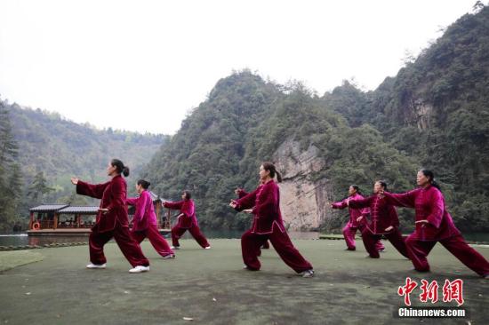 资料图：太极爱好者在湖南张家界宝峰湖风景区练习太极，畅享健身带来的快乐和健康。吴勇兵 摄
