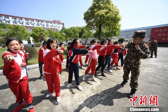 武警新余支队官兵向水西镇逸夫小学的学生传授擒敌拳。　周亮　摄