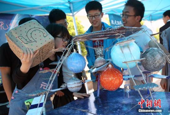 4月24日是中国航天日，南京航空航天大学的学生在校园内开展航天嘉年华活动，现场展出了该校自主研制的微小卫星和学生们用废纸箱制作的航天器模型，同时开展太阳观测、航天器拼图、航天主题趣味游戏等互动活动，吸引了众多学生前来参与，感受航天科技带来的惊喜。中新社记者 泱波 摄