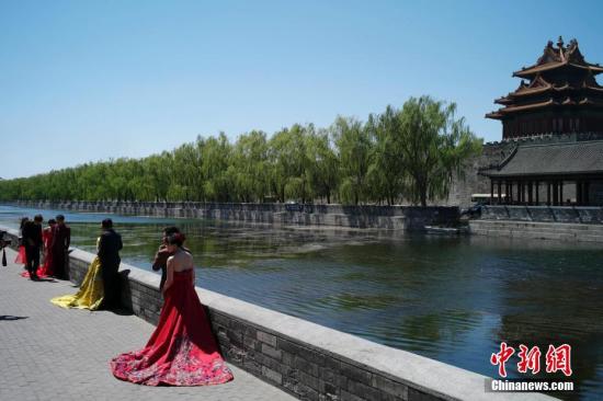资料图：4月27日，北京天气晴好，情侣在故宫外拍摄婚纱照。中新社记者 盛佳鹏 摄