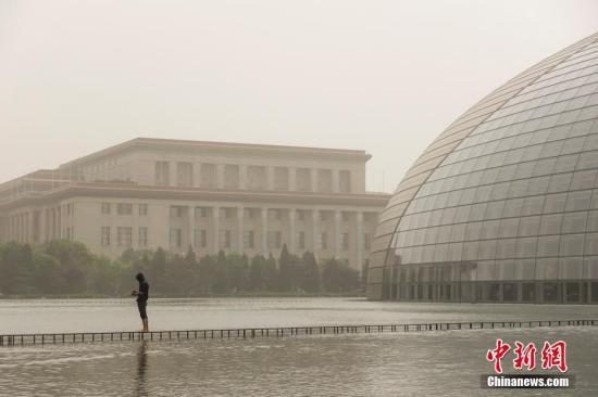 5月4日，北京遭遇沙尘过境，城区天空一片昏黄，局地PM10浓度破2000，空气质量达严重污染级别。图为国家大剧院与人民大会堂被沙尘笼罩。中新社记者 崔楠 摄