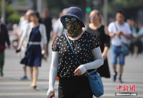 资料图：北京街头的民众防晒出行。中新社记者 杨可佳 摄