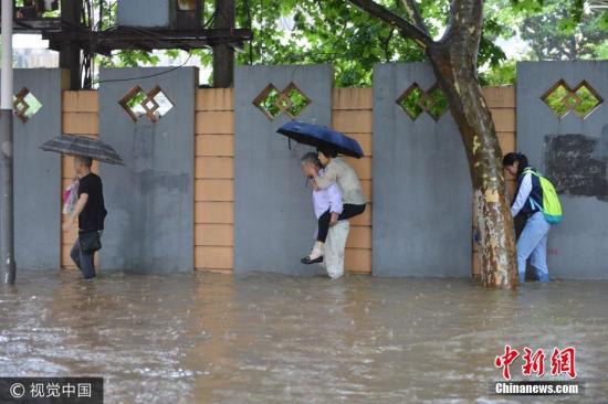 6月10日，南京市雨花台区，市民在水中艰难出行。图片来源：视觉中国