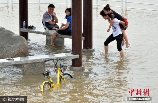 2017年6月29日，在武汉市武昌黄花矶，市民在江水漫过的亲水平台上玩耍。图片来源：视觉中国