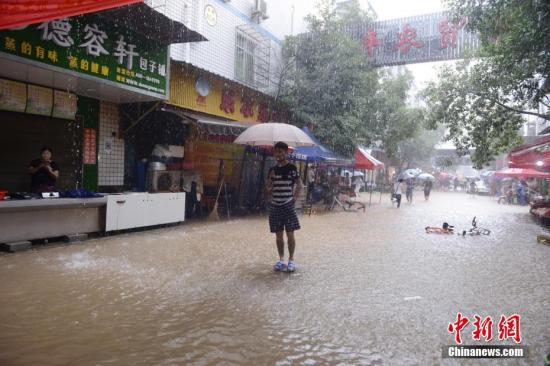 7月1日，一位市民站立在内涝的街道中央。当日，暴雨致长沙城区多处内涝。杨华峰 摄