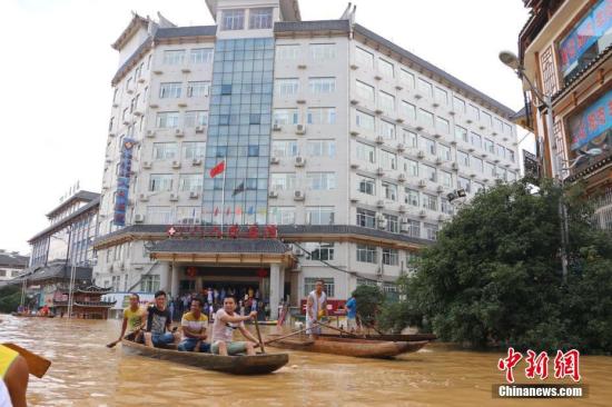 融水县城医院门前，居民划船接送病人。林馨 摄