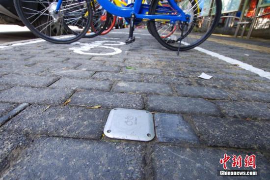 7月8日，北京三里屯地区的一处共享单车停车区域已加装电子围栏。电子围栏是通过地面的几个金属感应装置，接收到共享单车的停放信息，可兼容目前上市的各种共享单车。 中新社记者 贾天勇 摄